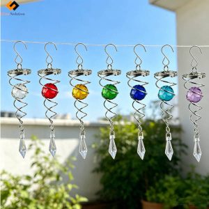 Multiple colorful wind spinner stabilizer tails hanging on a clothesline, featuring clear, red, yellow, green, dark blue, light blue, and purple faceted glass balls for garden spinners.