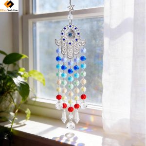 Rainbow gradient Hamsa Hand Suncatcher with evil eye casting colorful light patterns in a bright home interior.