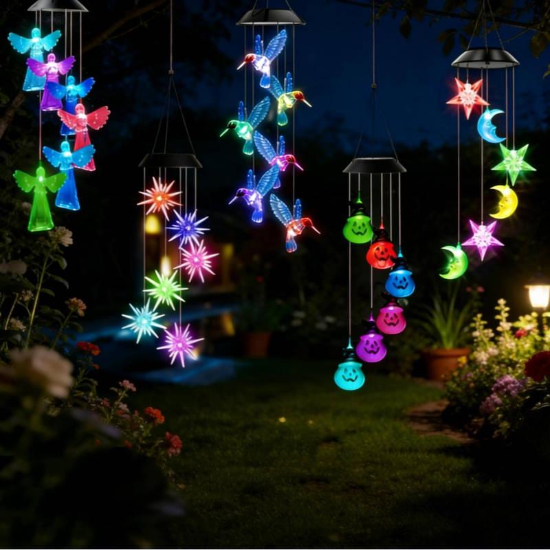 colorful solar light wind chimes featuring angels, stars, hummingbirds, and moons, glowing beautifully in a garden at night.